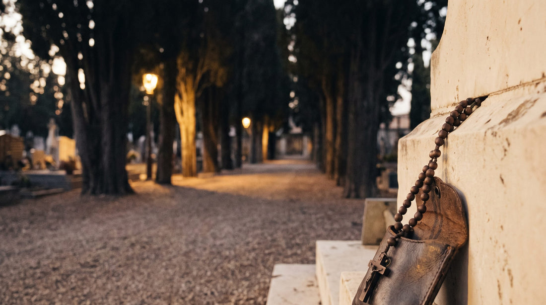 Chapelet pour les défunts : allée de cyprès dans un cimetière au crépuscule