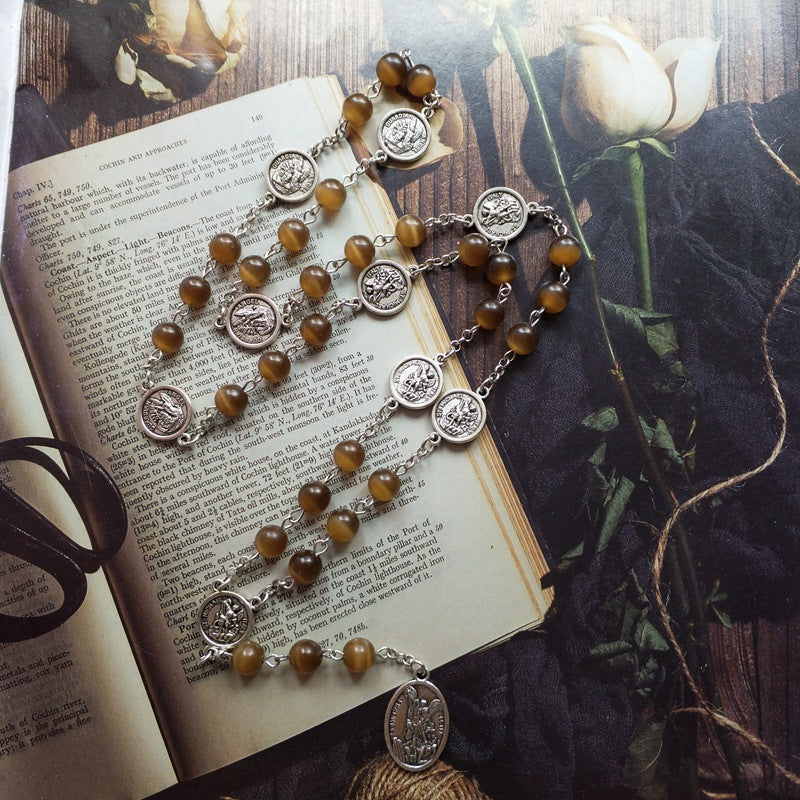 Le chapelet déployé sur les pages d'un livre ancien, ses médailles alternant avec les grains ambrés
